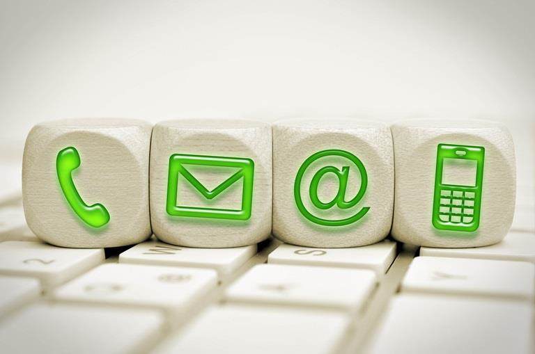 Green contact us symbols on cubes on a keyboard