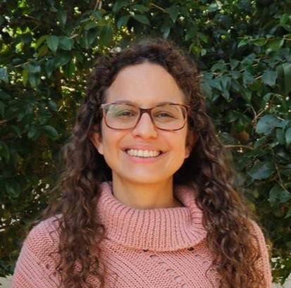Headshot of Poliana Gustavson against green trees